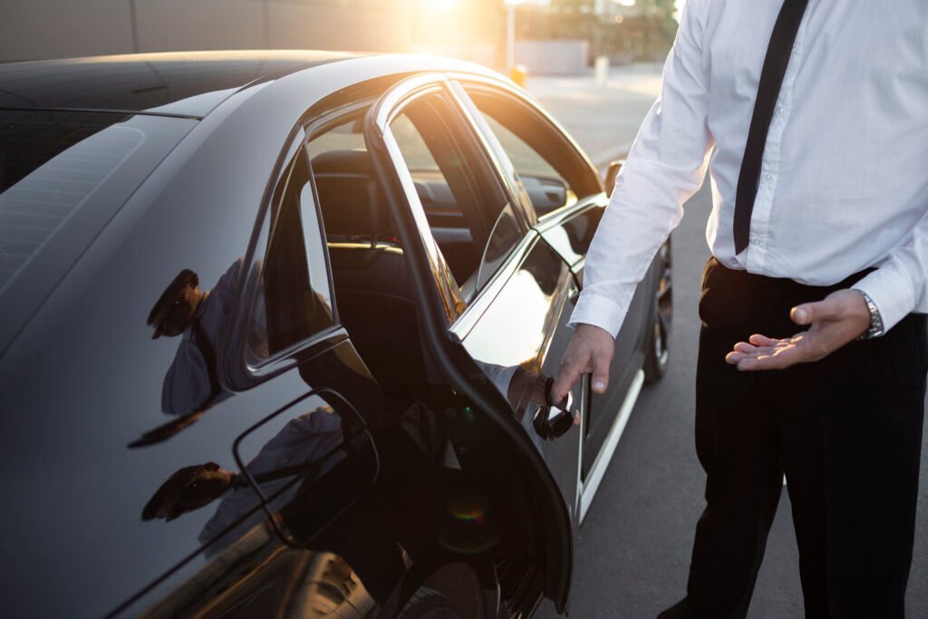 Transporte Privado No. 1 en Mérida | Servicio Seguro chofer de traje abriendo puerta de vehículo de lujo
